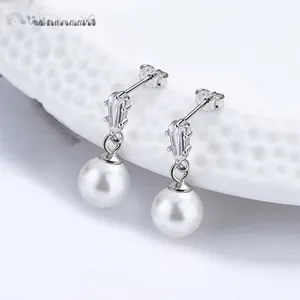 Dettaglio di orecchini di perle in stile francese con cristalli su piatto ceramico