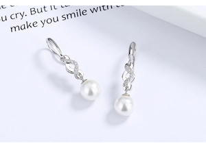 Detail of S925 silver pearl drop earrings featuring an infinity symbol with cubic zirconia