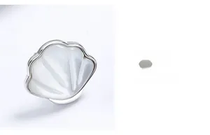 Detailed close-up of shell-shaped silver earring featuring polished white mother of pearl