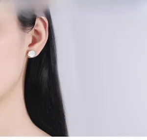 Close-up of model wearing 925 sterling silver shell earrings with white mother of pearl