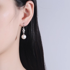 Elegant S925 silver pearl drop earrings with infinity zircon link on female model