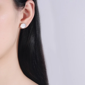 925 Sterling silver shell stud earrings with white mother of pearl on female model