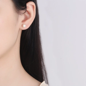 Orecchini a perno minimalisti con perla bianca in argento sterling 925 su modella