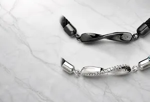 Primer plano de pulseras de pareja Mobius en negro y plata con grabado NO.52