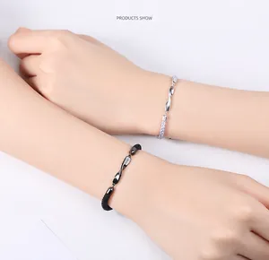 Detalle de dijes Mobius de plata 925 trenzados en pulseras para parejas de novios