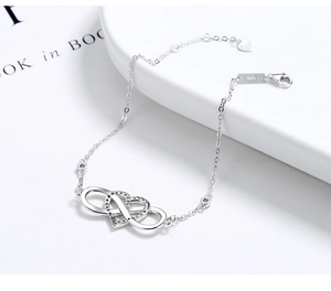Detail of S925 silver infinity heart bracelet with cubic zirconia and clasp logo