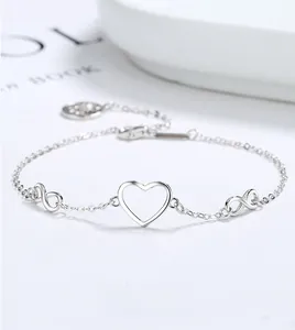 Detail of silver infinity heart bracelet featuring a delicate tree of life charm