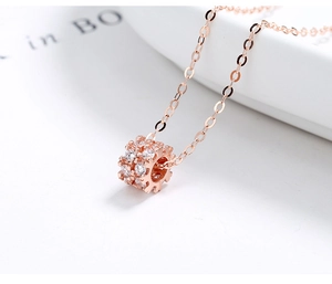 Vue macro du pendentif cylindrique en or rose serti de deux rangées de zircons blancs