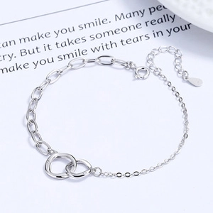 Detail of 925 sterling silver interlocking double ring bracelet with asymmetric chain