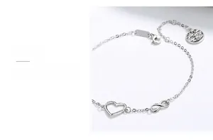 Detailed view of sterling silver infinity heart and tree of life charms on a fine chain