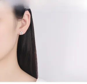 Close-up of star-shaped S925 silver stud earring with cubic zirconia on model's ear