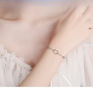 Close-up of 925 silver infinity heart bracelet worn on a female wrist with lace