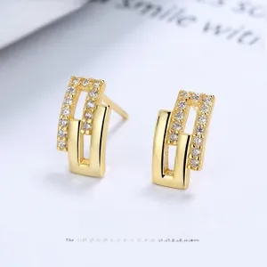 Detail of s925 silver C-shape hoop earrings with gold plating and zircon inlay