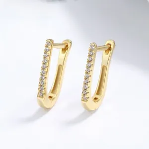 Detail of 18k gold plated U-shaped earrings featuring a row of sparkling white zircons