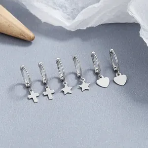 Set of 6 sterling silver hoop earrings with heart, star, and cross pendants on gray texture