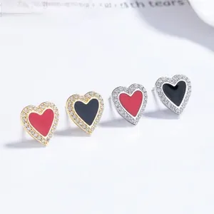 Macro shot of 925 silver dolphin heart earrings with red black enamel and cubic zirconia