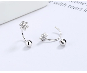 Macro detail of S925 sterling silver flower earrings with zircon petals and screw ball backs