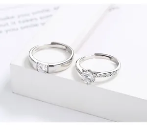 Close-up of S925 sterling silver couple rings with six-prong zircon setting on white stand