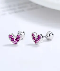 Detailed macro shot of 925 silver heart stud earrings with sparkling pink zircons