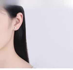 Minimalist S925 sterling silver hexagonal stud earring shown on a model's ear