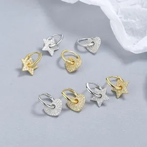 Macro detail of 925 silver star and heart earrings with micro zircon stone inlay