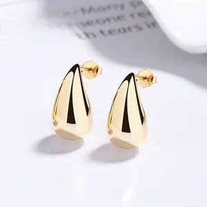 Close-up of golden teardrop stud earrings with S925 silver hallmark on the backing