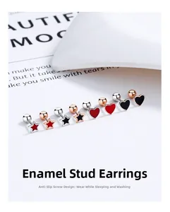 Detailed macro view of enamel star and heart screw back stud earrings in gold and silver