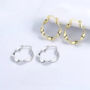Detail view of wavy twisted hoop earrings in gold and silver finish on card