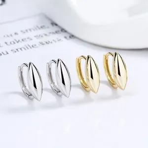 Macro detail of high-polish silver and gold drop earrings showing sleek mirror finish