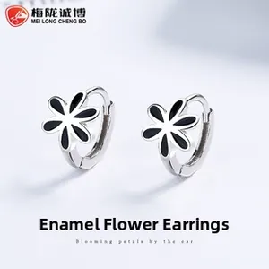 Close-up of S925 silver hoop earrings featuring black enamel floral patterns on light blue background