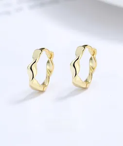 Macro shot of 925 sterling silver Mobius earrings with golden wave pattern finish