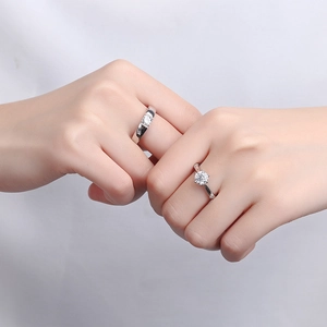 Classic 925 sterling silver couple rings with six-prong zircon stone on white fabric