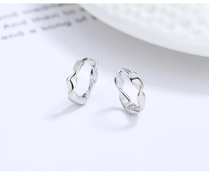 Macro detail of polished Mobius hoop earrings in 925 sterling silver with a twisted wave design