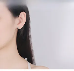 Close-up of polished S925 sterling silver teardrop stud earring on female model ear
