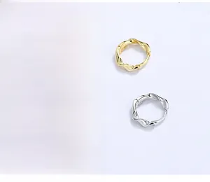 Detailed view of silver and gold Mobius hoop earrings showing S925 engraved stamp