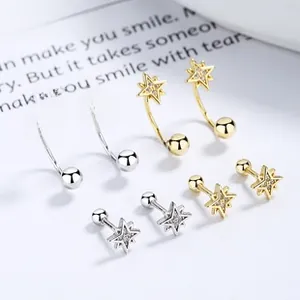 Detail view of gold and silver 925 sterling silver star earrings with zircon inlay