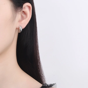 S925 sterling silver croissant hoop earrings with a twisted rope texture on female model