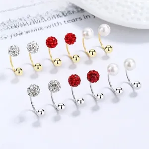 Detail of silver and gold U-shaped earrings with crystal pave balls and pearls