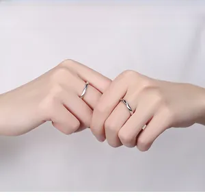 Detail of silver S925 Amour couple rings with minimalist mobius twist design on hands