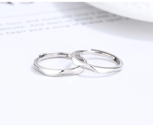 Close-up of S925 sterling silver couple rings with Amour engraving and Mobius design