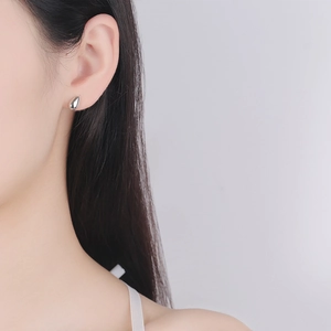 S925 sterling silver teardrop stud earrings with polished mirror finish on model