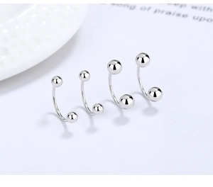 Macro shot of silver S925 sterling silver U-shaped screw earrings in four sizes