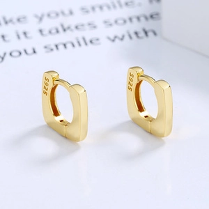 Macro shot of S925 hallmark on minimalist square gold-plated silver huggie hoop earrings