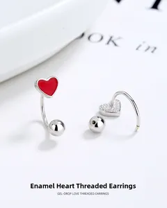 Detailed macro view of enamel heart threaded earrings with polished silver finish
