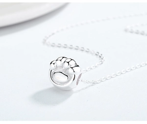 Macro shot of polished S925 sterling silver cat paw pendant with delicate O-chain