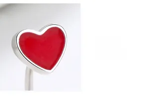 Macro detail of red enamel heart earring with 925 silver frame and screw thread design