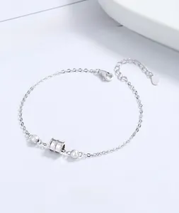 Macro shot of silver cylinder pendant bracelet with faceted beads on an O-chain