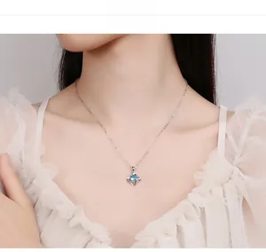 Close-up of 925 silver four-leaf clover pendant necklace with blue zircon on model
