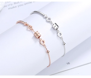 Detail of rose gold and silver cylinder pendants on minimalist S925 sterling silver bracelets