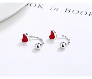 Detail of S925 sterling silver hoop earrings featuring a red enamel heart and metal bead
